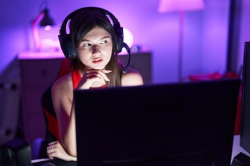 Wall Mural - Young caucasian woman streamer sitting on table with serious expression at gaming room