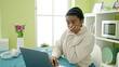 © Krakenimages.com - African american woman using laptop sitting on table at dinning room