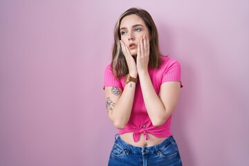 Sticker - Blonde caucasian woman standing over pink background tired hands covering face, depression and sadness, upset and irritated for problem