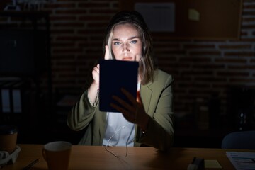 Sticker - Blonde caucasian woman working at the office at night pointing with finger up and angry expression, showing no gesture