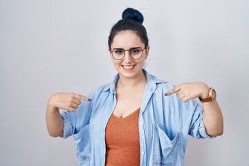 Wall Mural - Young modern girl with blue hair standing over white background looking confident with smile on face, pointing oneself with fingers proud and happy.