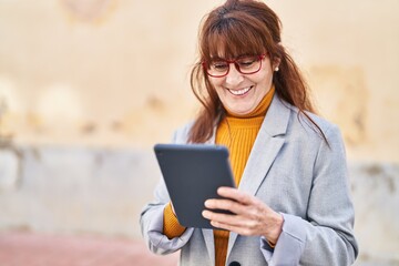 Sticker - Middle age woman business executive using touchpad at street