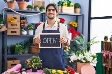 Canvas Print - Hispanic man with long hair working at florist holding open sign smiling with a happy and cool smile on face. showing teeth.