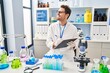© Krakenimages.com - Young hispanic man scientist looking test tubes write on document at laboratory