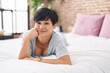 © Krakenimages.com - Middle age chinese woman smiling confident lying on bed at bedroom