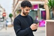 © Krakenimages.com - Young arab man smiling confident using smartphone at street