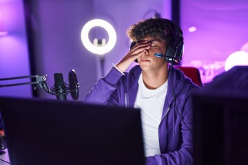 Poster - Young hispanic teenager streamer stressed using computer at gaming room