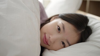 Poster - Young chinese woman smiling confident lying on bed at bedroom