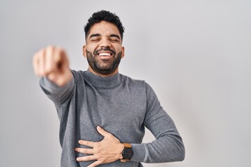 Canvas Print - Hispanic man with beard standing over white background laughing at you, pointing finger to the camera with hand over body, shame expression