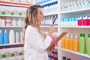 Sticker - Young blonde woman pharmacist writing on document at pharmacy