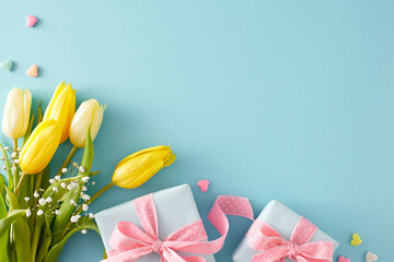Wall Mural - Flat lay photo of gift boxes with bows small hearts baubles bouquet of yellow white tulips and gypsophila flowers on pastel blue background with empty space. Mother's Day celebration concept