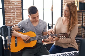 Canvas Print - Man and woman musicians having classic guitar lesson at music studio