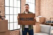 © Krakenimages.com - Middle age caucasian man holding welcome doormat at new home depressed and worry for distress, crying angry and afraid. sad expression.