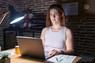 Sticker - Brunette woman working at the office at night skeptic and nervous, frowning upset because of problem. negative person.