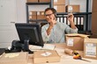 © Krakenimages.com - Senior man working at small business ecommerce wearing headset smiling and looking at the camera pointing with two hands and fingers to the side.