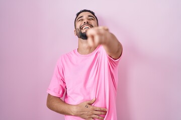 Canvas Print - Hispanic young man standing over pink background laughing at you, pointing finger to the camera with hand over body, shame expression