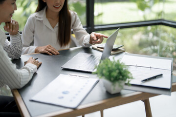 Wall Mural - Confident young asian business woman working on laptop. Creative female executives meeting in modern startup office.