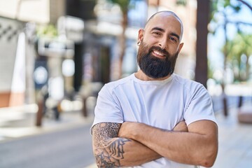 Canvas Print - Young bald man standing with arms crossed gesture at street