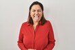 Hispanic mature woman standing over white background sticking tongue out happy with funny expression. emotion concept.