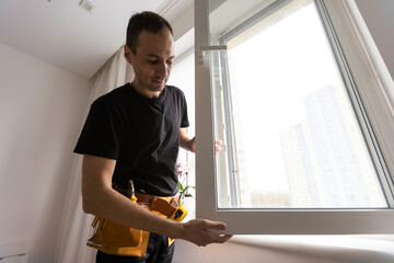 Worker in installing rubber seals on plastic upvc window.