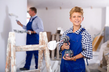 Portrait Of Little Smiling Boy With A Screwdriver In His Hands In A Renovated Room