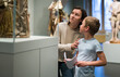 © JackF - Attentive young woman with school age boy visiting sculptures exposition in museum