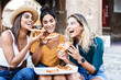 © Xavier Lorenzo - Three young happy women eating pizza having fun laughing enjoying time together on summer vacation in Italy. People, female friendship and holidays concept.
