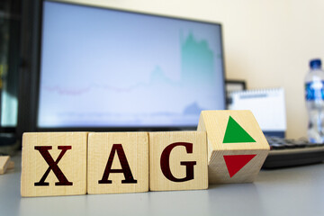 Wooden cubes with the inscription xag and a cube symbolizing the rise and fall of financial markets