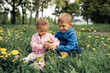 © kieferpix - Best friends little brother sharing giving a flower to his little sister. Siblings friendship portrait in a green meadow field.
