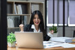 © Natee Meepian - Happy excited successful businesswoman triumphing in office