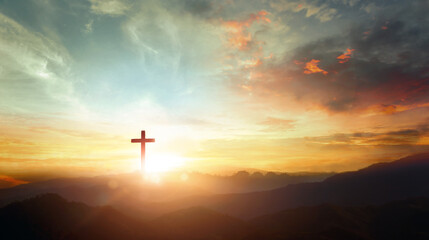 Wall Mural - The crucifix symbol of Jesus on the mountain sunset sky background