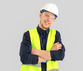 Wall Mural - Male worker in vest and hardhat on grey background