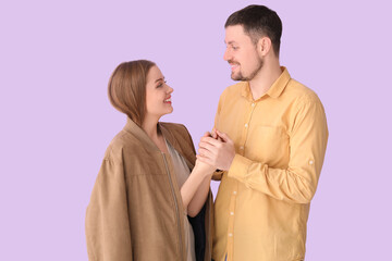 Sticker - Young man and wife in his jacket holding hands on lilac background