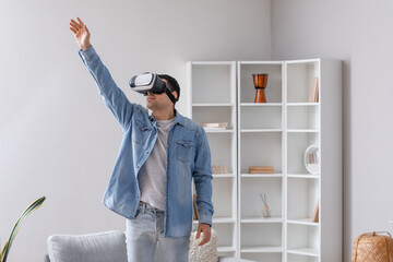 Wall Mural - Young man using VR glasses at home