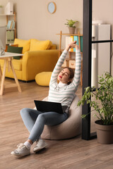 Poster - Female programmer with laptop stretching in office