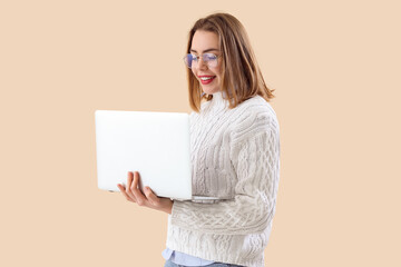 Female programmer working with laptop on beige background