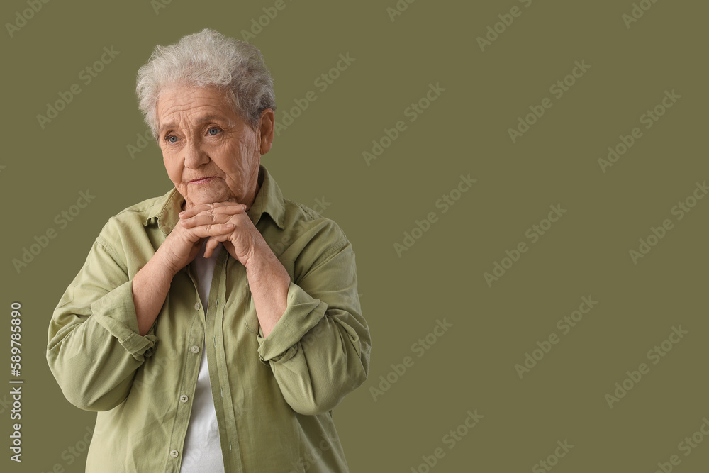 Thinking senior woman on green background
