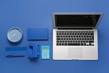 Wall Mural - Composition with laptop, calculator and clock on blue background