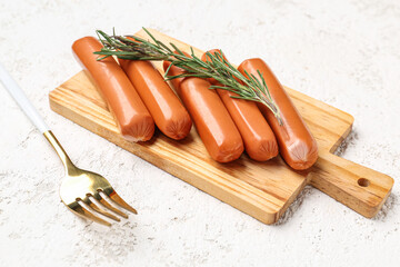 Wall Mural - Wooden board with tasty sausages on light background