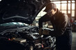 © ttonaorh - Professional mechanic working on the engine of the car in the garage. Car repair service. The concept of checking the readiness of the car before leaving