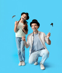 Poster - Portrait of father and his little daughter with paper mustache on light blue background