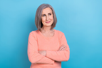 Poster - Photo of confident dreamy lady dressed coral shirt looking empty space arms crossed isolated blue color background