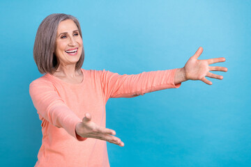 Poster - Photo of cheerful kind funny grandmother dressed pink pullover catching product look empty space isolated on blue color background