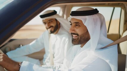 Wall Mural - Two friends making the safari in the Dubai desert. Locals with kandura white outfit spending time together with the 4x4 car on the dunes in sharjah. Concept about traveling in the united arab emirates