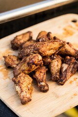 Poster - Vertical shot of grilled chicken wings on a wooden board