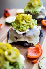 Canvas Print - Vertical shot of burger sliders with pickled jalapenos and grilled veggies on a wooden table