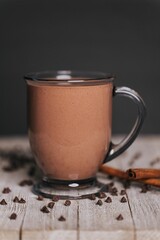 Sticker - Vertical shot of a cup of hot chocolate on the wooden background