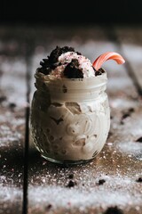 Poster - Closeup shot of a delicious cookie shake in a glass jar surrounded by icing sugar