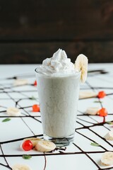 Wall Mural - Closeup shot of a tall glass cup of milkshake topped with whipped cream