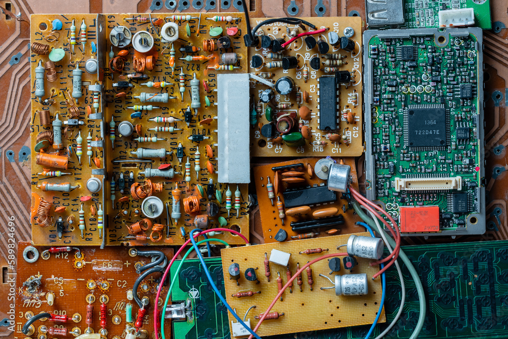Many old printed circuit board with radio components on background. Vintage circuit boards with soldering trace, parts and microcircuits, closeup, top view. Electronic retro style design